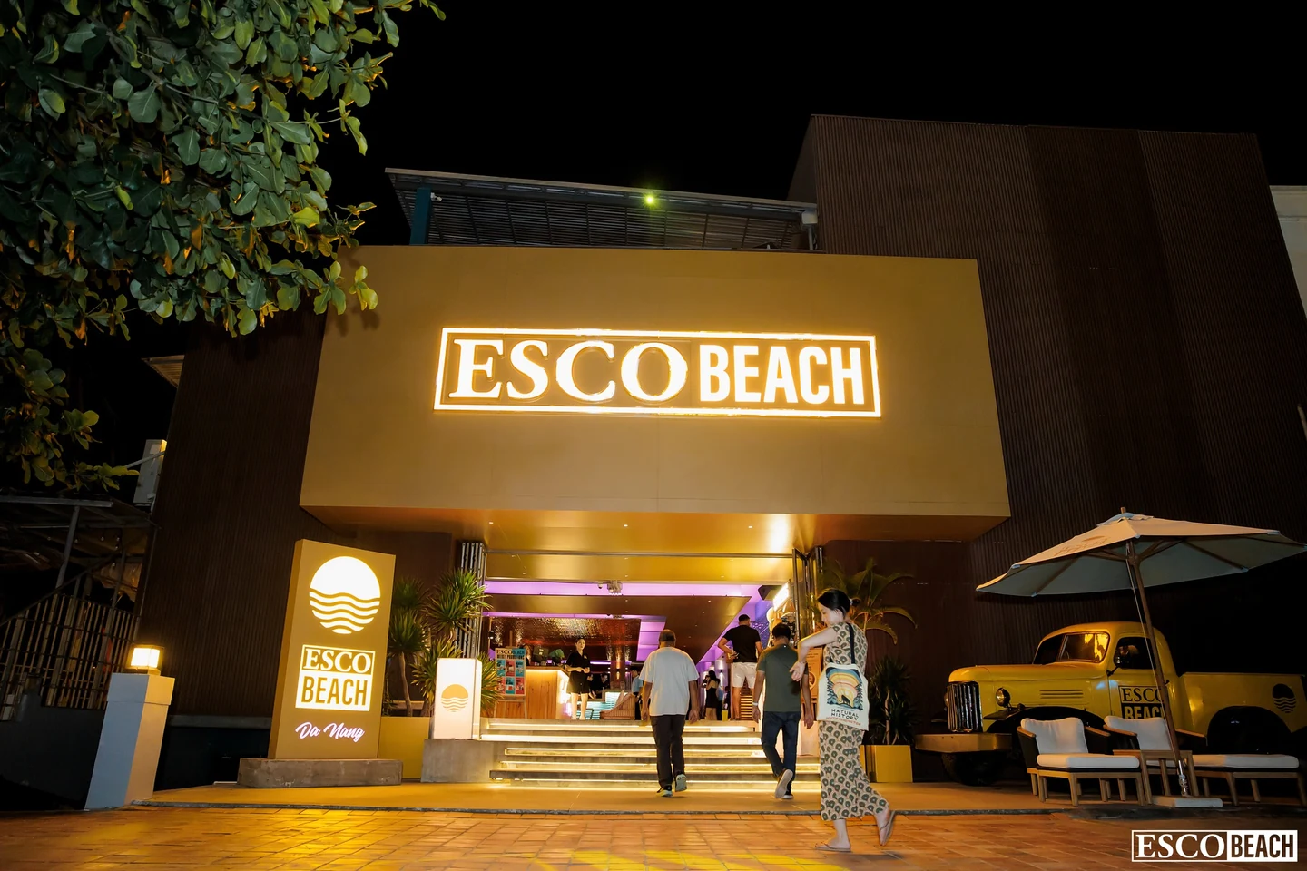 다낭 에스코 비치 야간 입구의 ESCO BEACH 조명 간판과 방문객 모습